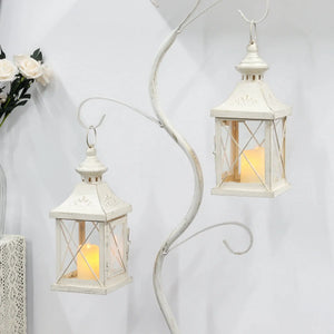 Set of 2 white distressed 11in decorative candle lanterns with glass panes and glowing candles.
