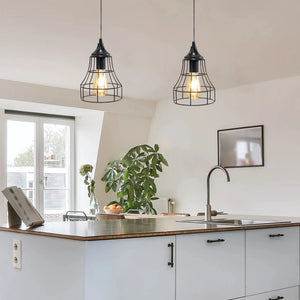 Set of 2 black metal cage pendant lamps with exposed bulbs over a kitchen island