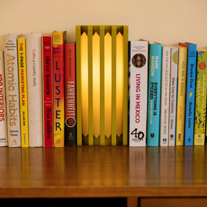 Radiator Table Lamp by Terra Labs, golden-yellow radiator-style lamp on a bookshelf.
