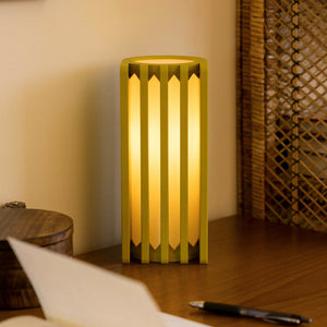 Radiator Table Lamp by Terra Labs; lime-yellow metal frame with vertical slats emits warm glow.