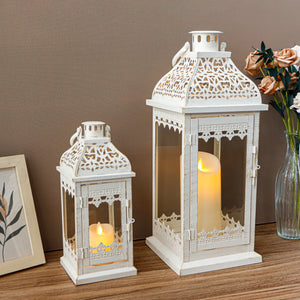 Set of 2 decorative candle lanterns, 13 and 19.5 inches tall, white distressed metal with lattice panels.