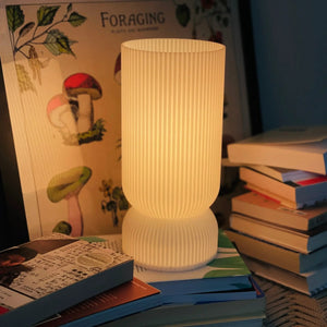 Stance Table Lamp by Terra Labs; white ribbed shade, warm glow.