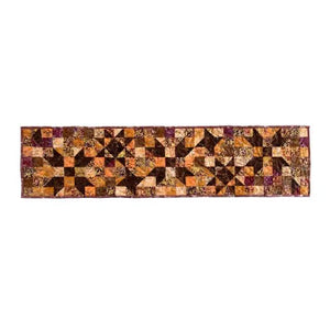 Quilt kit table runner with autumn star blocks; cotton precut pieces in orange, brown, and purple.