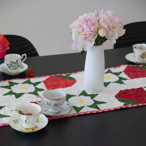 Strawberry Table Runner Kit, quilt kit with red strawberry patchwork on white fabric and green leaves