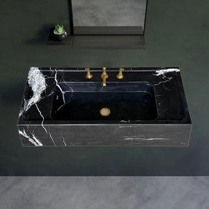 Toros black marble rectangular wall-mount bathroom sink with gold faucet.