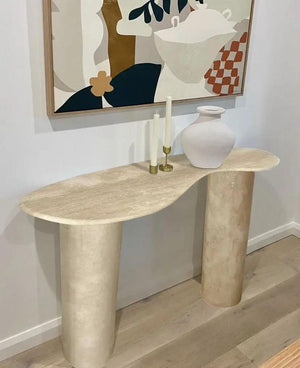Troia Light Travertine Console; beige travertine with twin pedestal legs, white vase and two candles on top