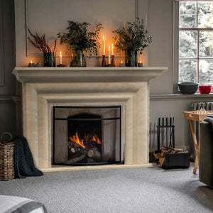 Troia Light Travertine modern hand-carved fireplace surround in a cozy living room.