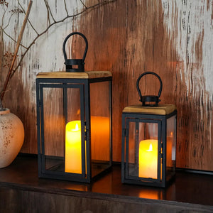 Set of 2 decorative candle lanterns, black metal with wood tops and glass panels, 16" and 11" tall, by JHY DESIGN.