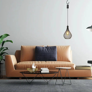 Set of 2 hanging lamps, battery-operated teardrop cage pendants in dark metal over a living room sofa.