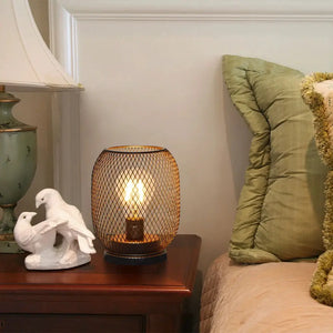 Set of 2 egg-shaped LED table lanterns with bronze mesh, battery-operated, on a bedside nightstand.