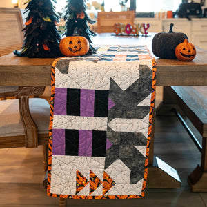 Witches Feet Table Runner Precut Quilt Kit by Block Party Quilt Co in Halloween purple, black, orange patchwork.