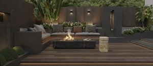 Freestanding black marble fire pit table with glowing flames in a modern outdoor lounge with neutral cushions.