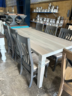 Levi 5 slat dining chairs by Wooden Whale Workshop in gray-washed wood around a light dining table.