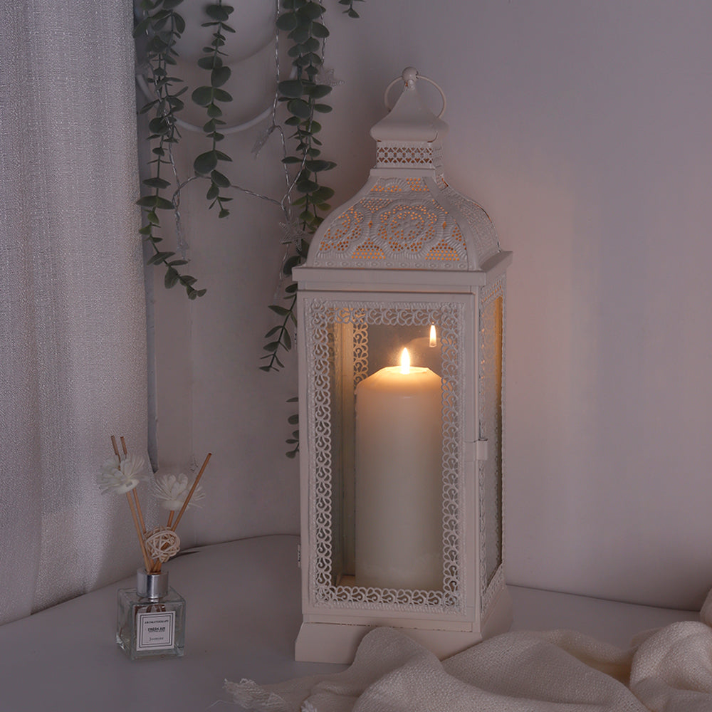 Rustic white metal decorative candle lantern with tempered glass panels and a lit candle