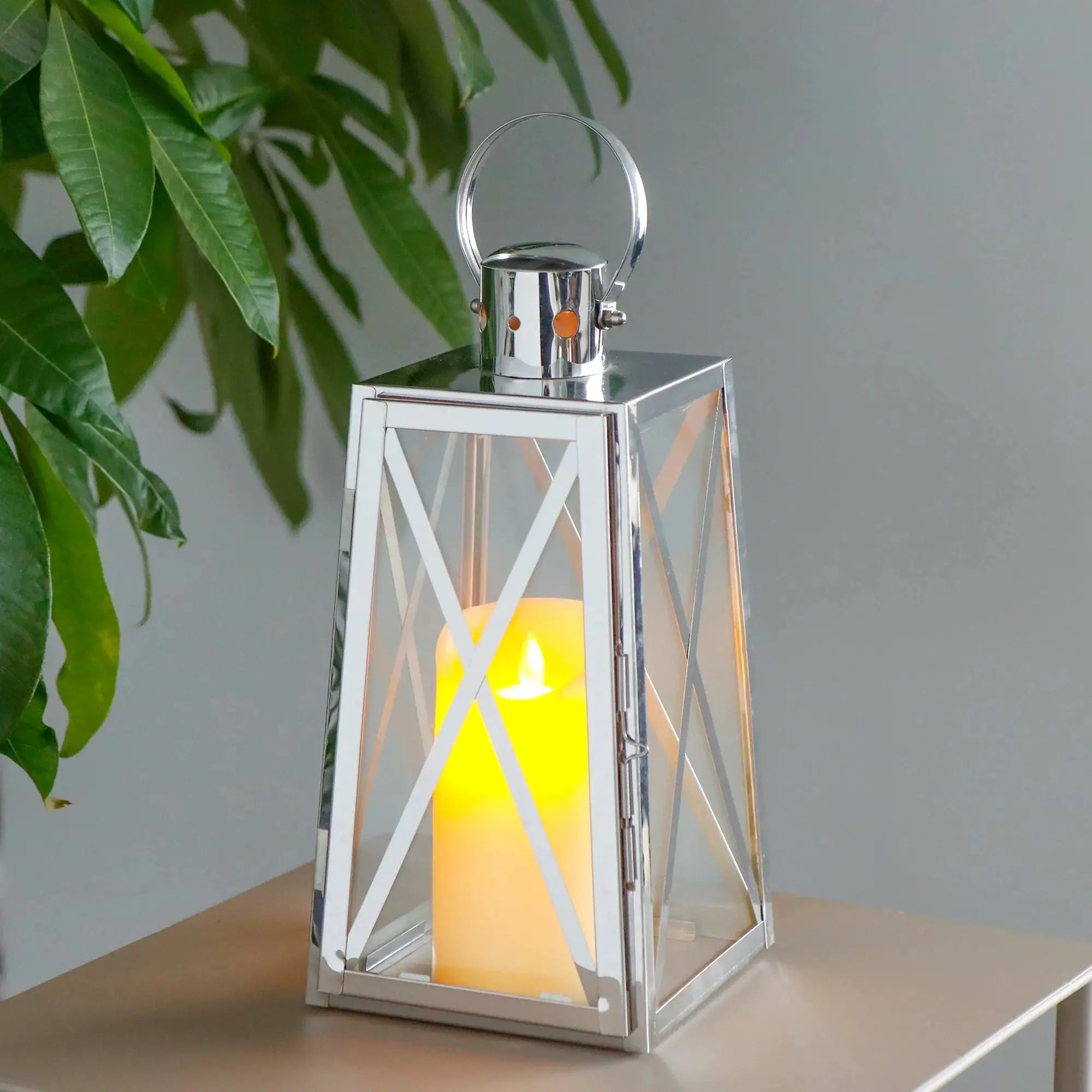 Decorative lantern 12''H trapezoid stainless steel by JHY DESIGN with glass panels and warm candle glow