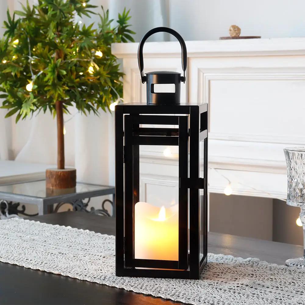 12'' High Metal Decorative Candle Lantern (Black) by JHY DESIGN with a lit candle inside.