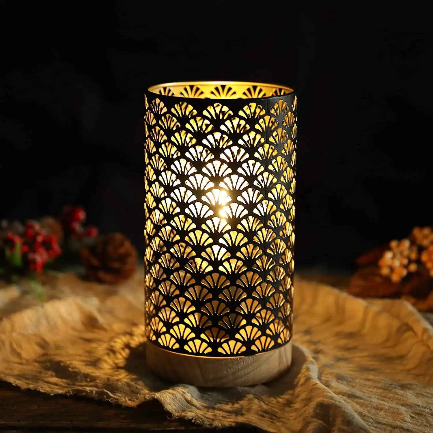 7.5in high metal cordless lamp with an intricate perforated pattern and warm glow on a wooden base
