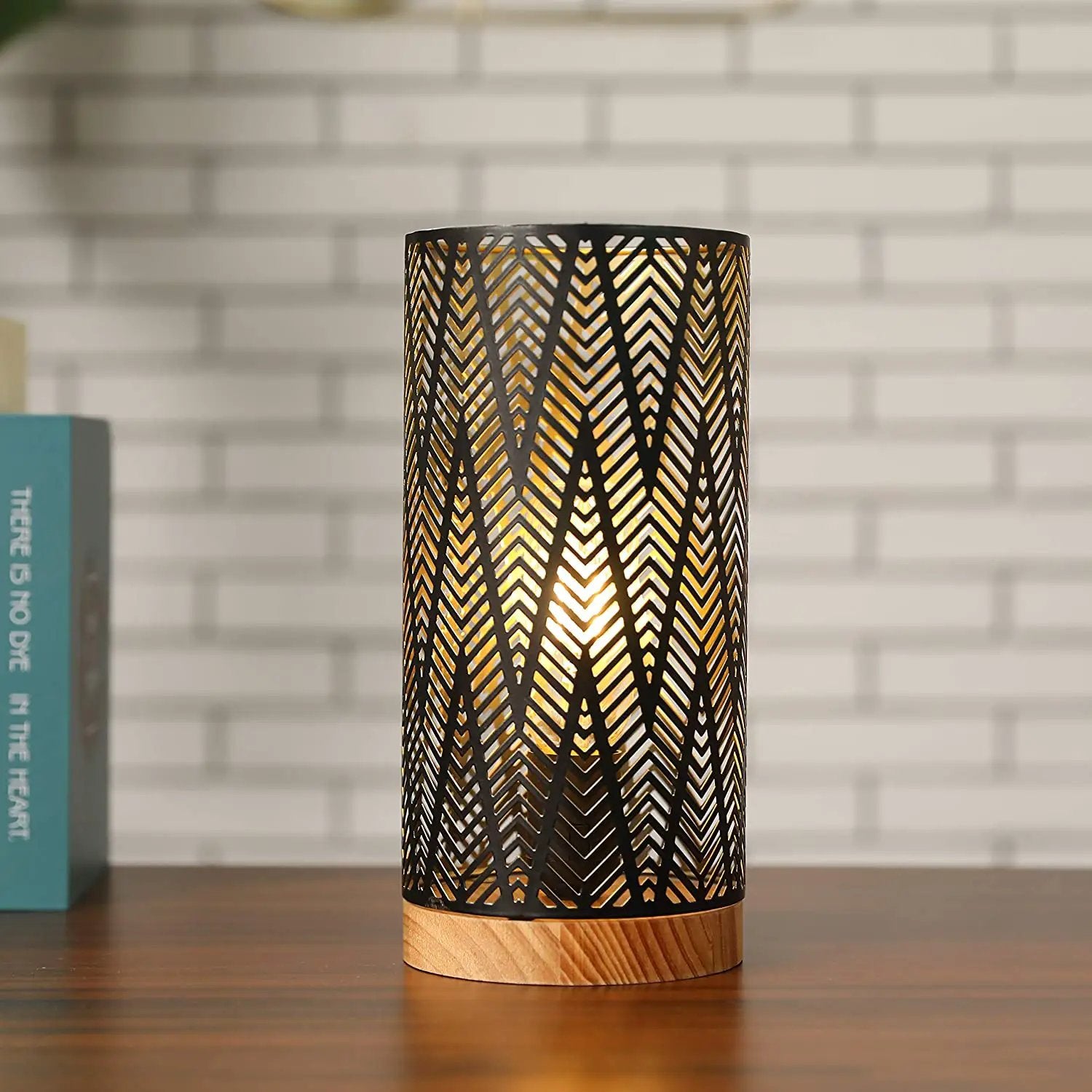 11'' High battery-powered metal lamp with black perforated shade and wooden base, emits warm light.