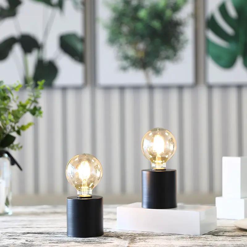 7-inch tall black battery-powered table lamps set of 2 with clear glass bulbs.