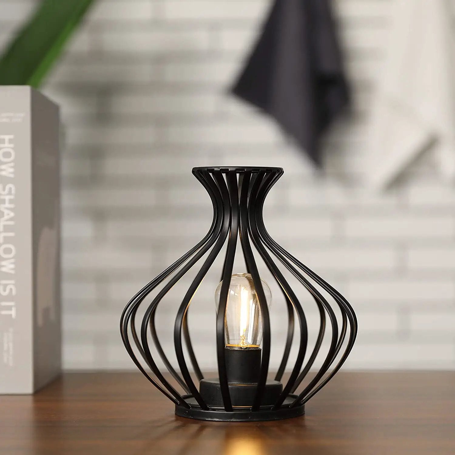 7.5in LED wireless table lamp with black metal wireframe and exposed bulb.