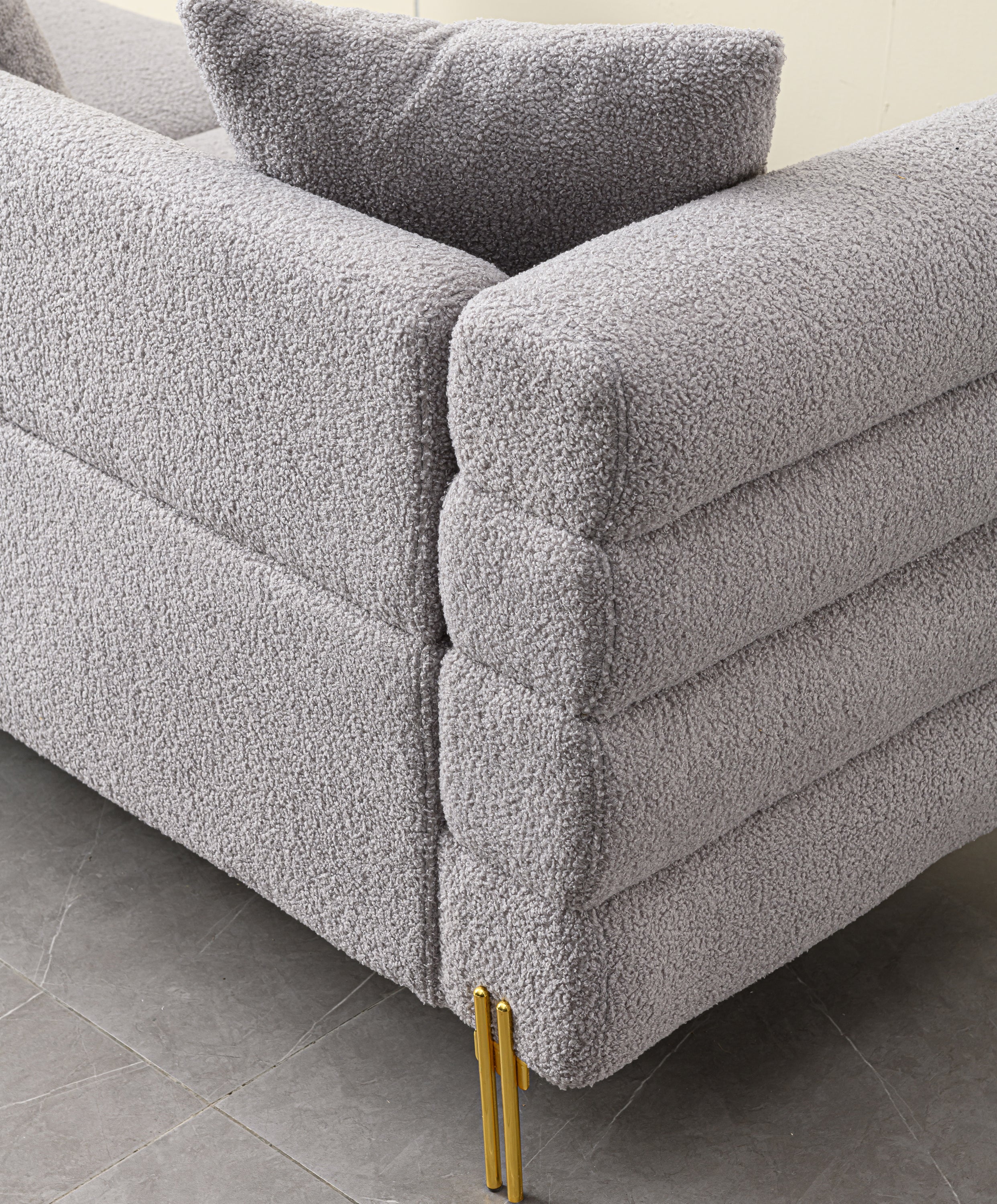 Luxurious and comfortable upholstered sofa with golden legs and pillows for living room and reception area