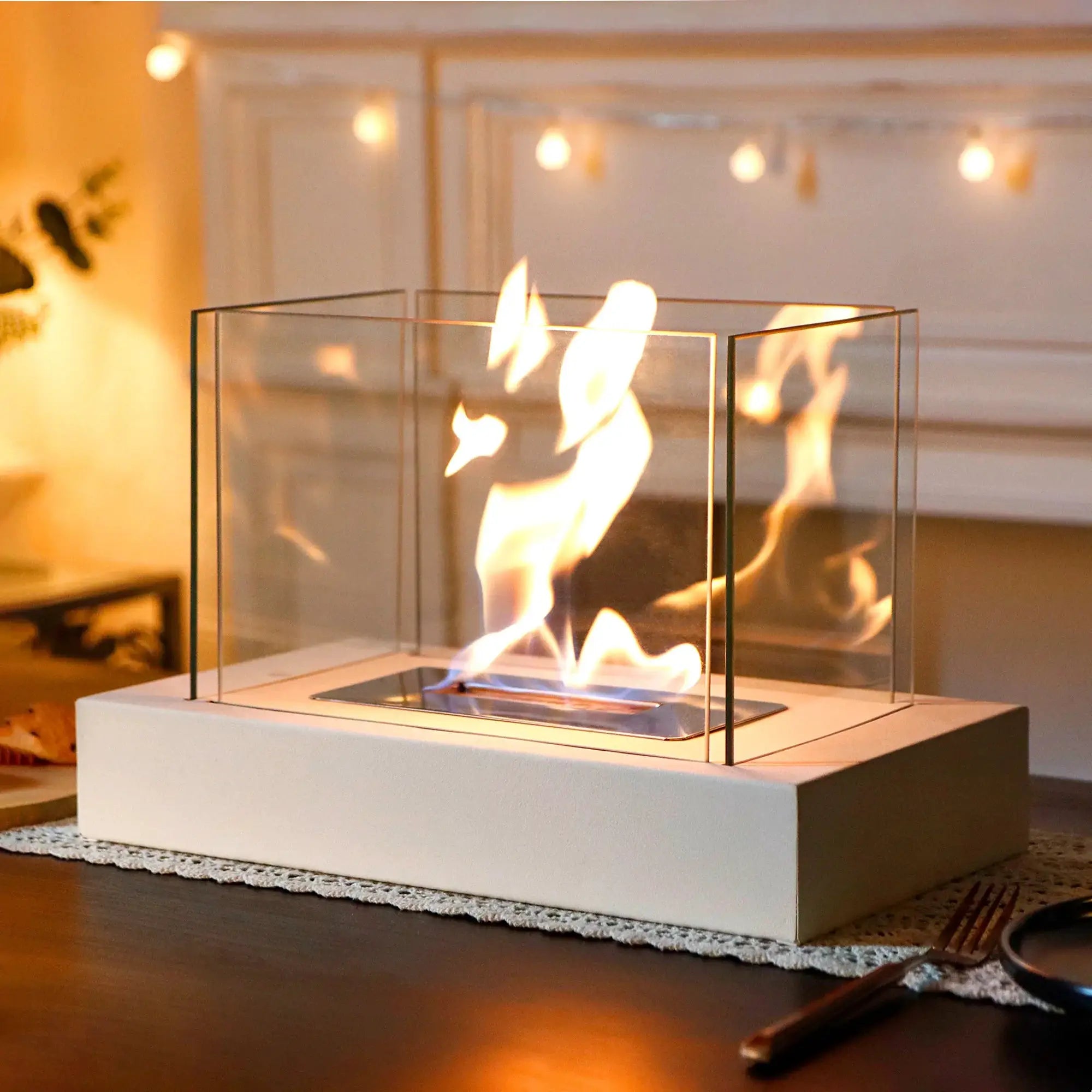 360° Rectangular tabletop fire bowl with four-sided glass enclosure and visible flames on a white base