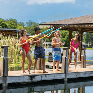 WOW Watersports Splash Cannon water toy 12-pack on a dock with kids launching blue and yellow cannons.