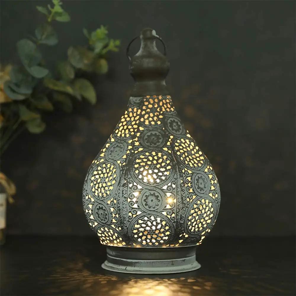 11.5in tall battery-powered table lamp by JHY DESIGN with ornate perforated metal teardrop shade and warm glow.
