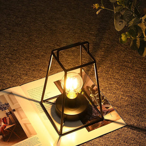 11.5in high retro geometric table lamp with a black metal cube frame and warm Edison bulb
