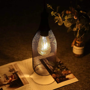 Battery-powered hanging lamp with black metal mesh cage and warm glow.