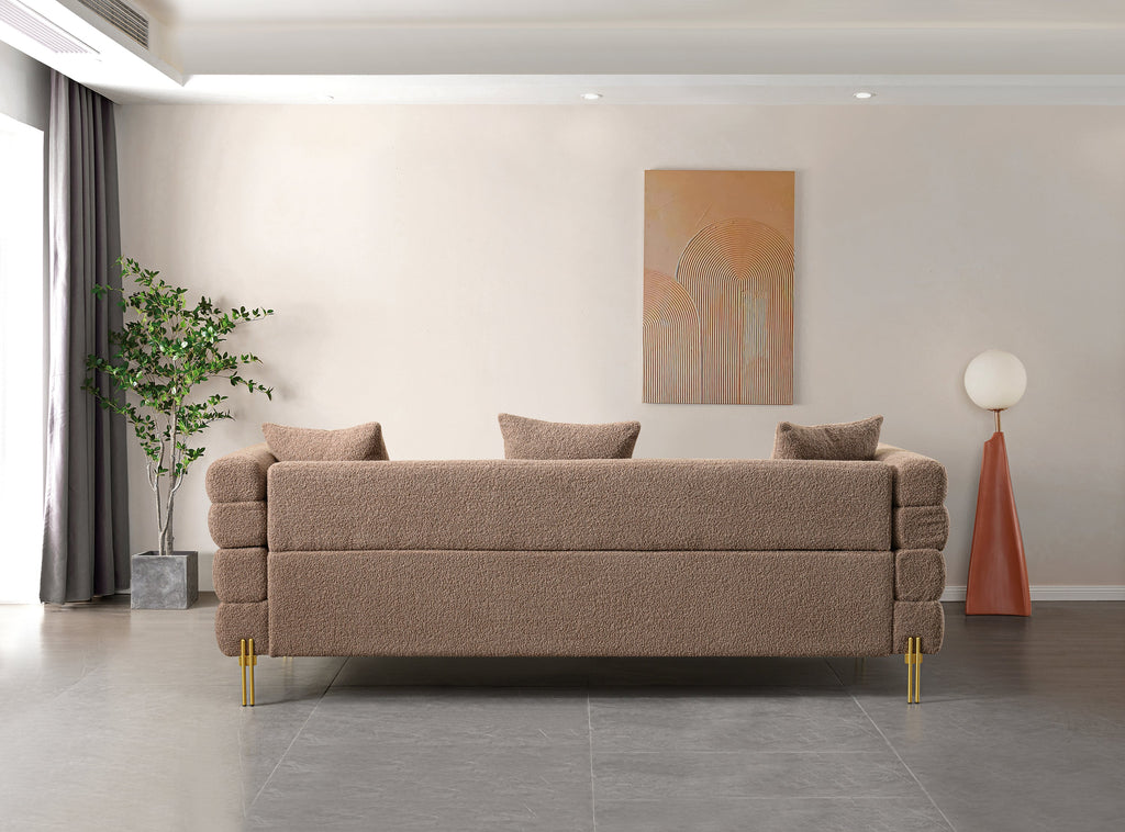 Luxurious and comfortable upholstered sofa with golden legs and pillows for living room and reception area