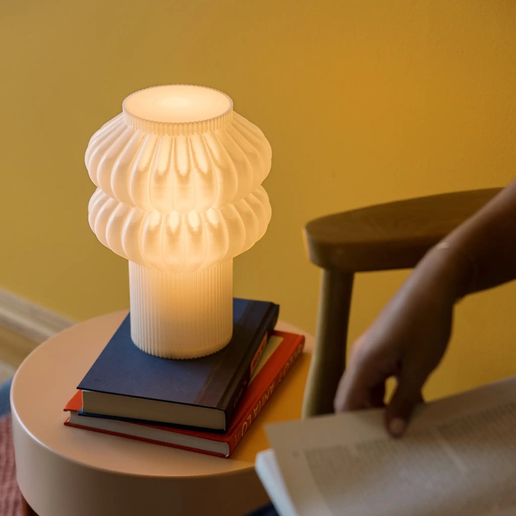 Oppi table lamp with white ribbed glass shade emitting warm light