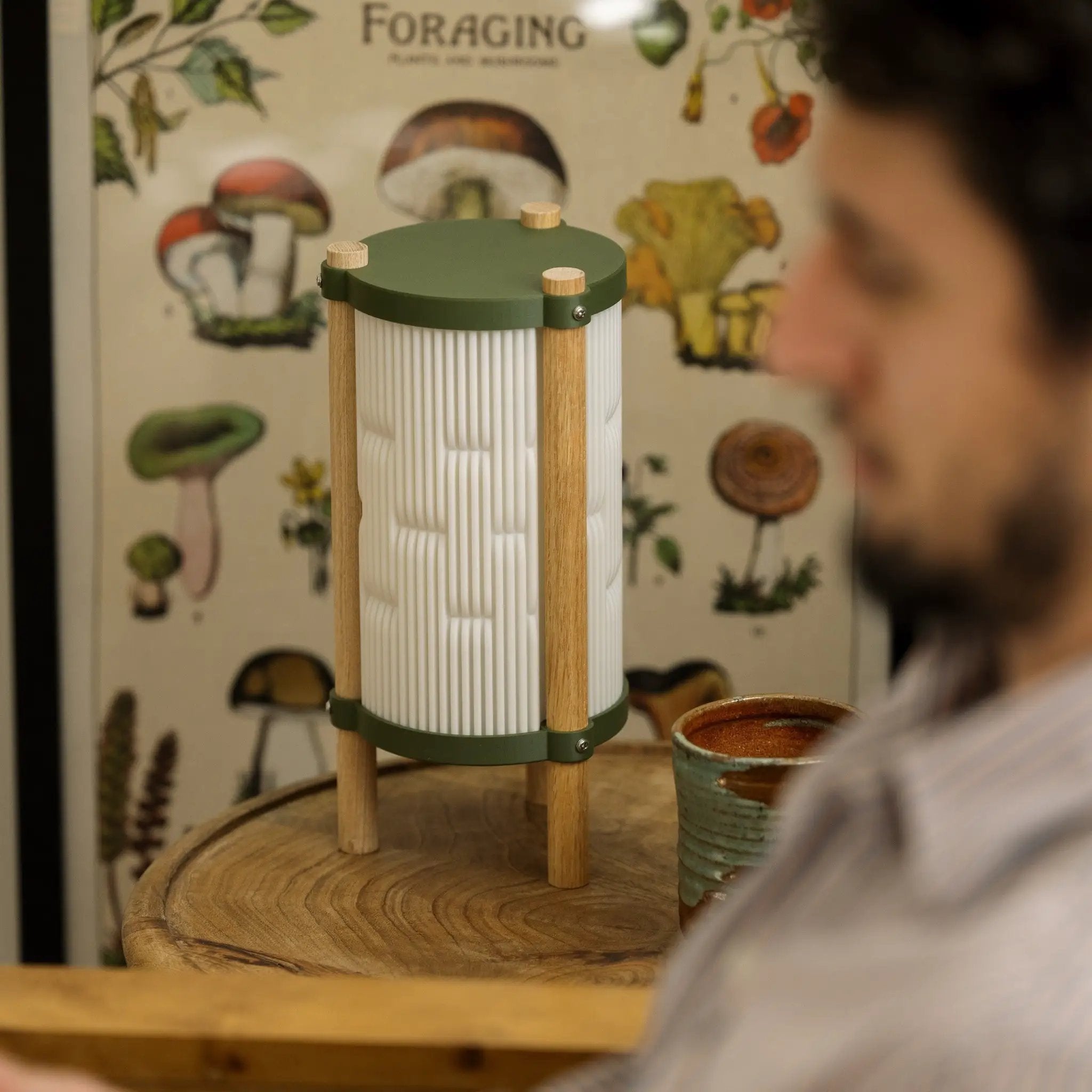Toro Table Lamp by Terra Labs; green metal accents, wooden legs, ribbed white shade.
