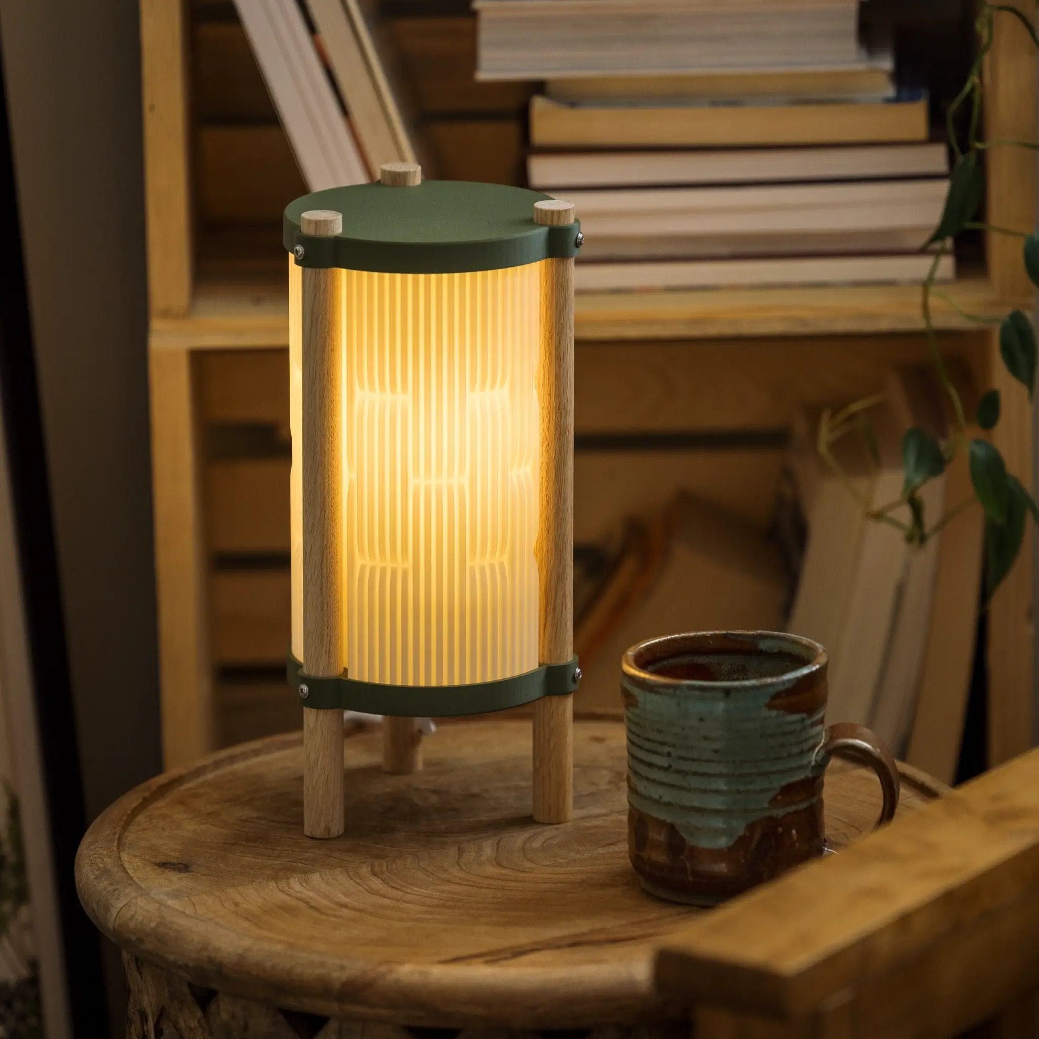 Toro table lamp by Terra Labs; green metal and wood pedestal with warm ribbed glass shade.