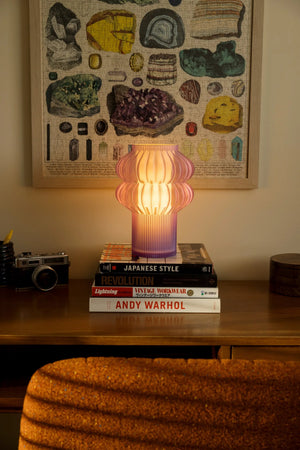 Oppi table lamp, pink ribbed glass by Terra Labs, warm glow on desk