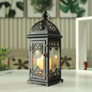 15-inch high decorative candle lantern in black metal with ornate lattice panels and glass, candle inside