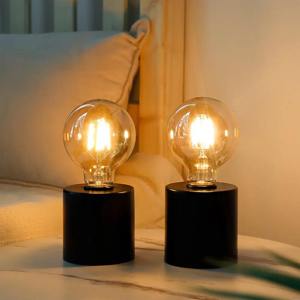 7-inch tall black battery-powered table lamps, set of 2, with clear glass globe bulbs.