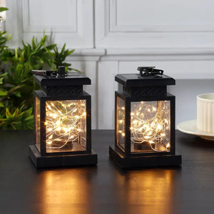 Set of 2 solar lantern lights, black metal lanterns with warm string lights.