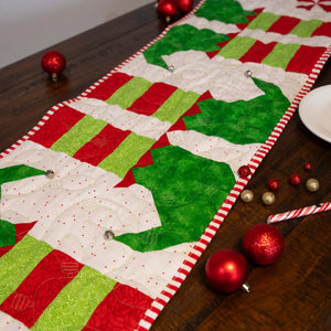 Elf Feet Christmas Table Runner quilt kit, precut; red and green patchwork with candy-cane binding.