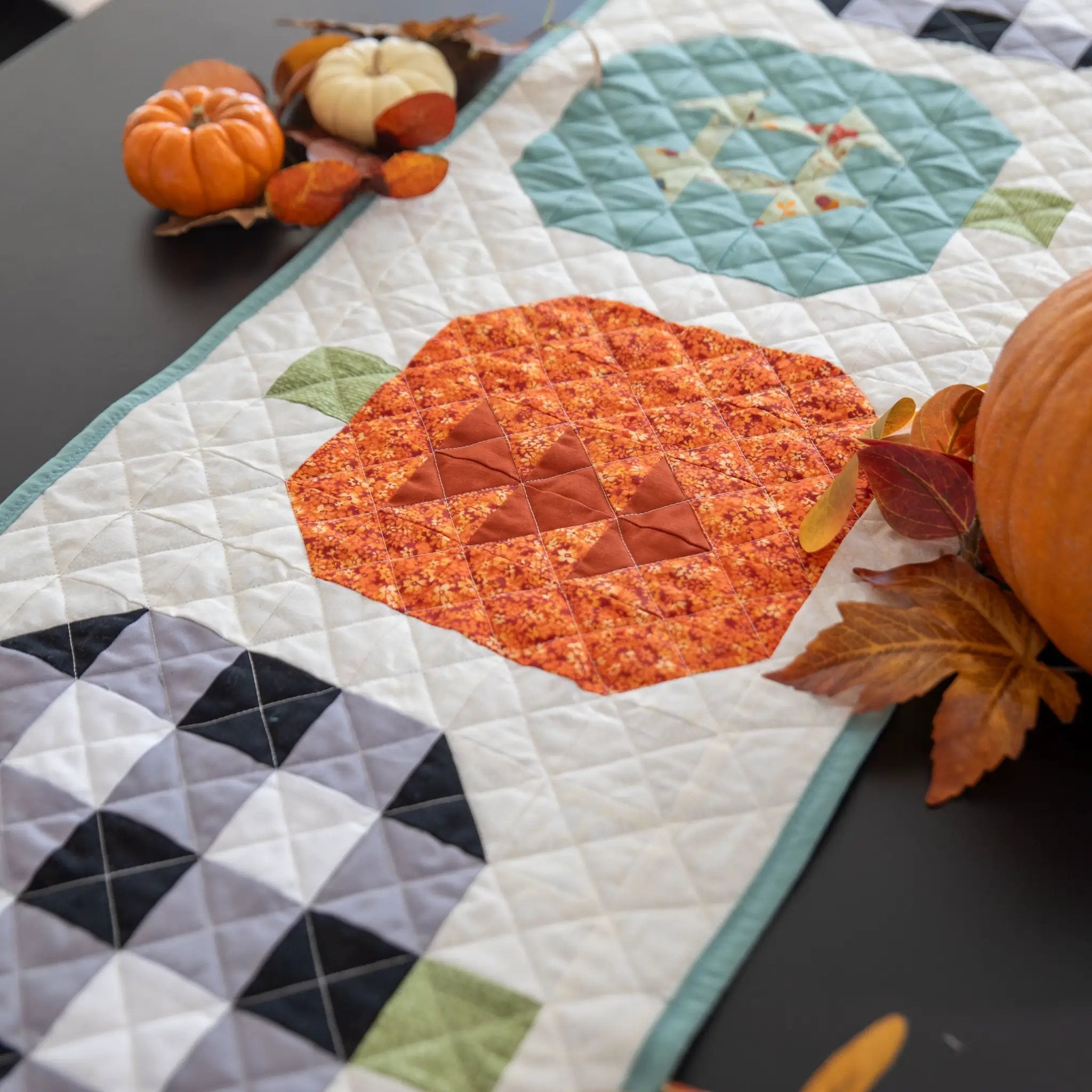 Quilt kit: Pumpkin Patchwork Table Runner with autumn pumpkins and turquoise border by Block Party Quilt Co.