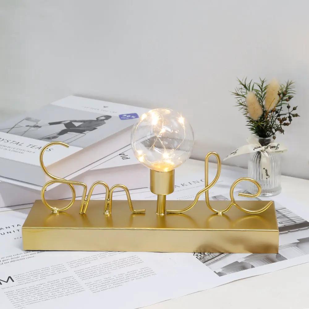 Decorative cordless lamp by JHY DESIGN with warm white fairy lights, gold base and Smile wire sculpture