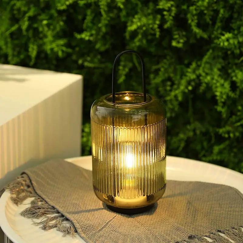 JHY DESIGN 11.5in amber-green battery-powered table lamp with ribbed glass and a metal handle on an outdoor table