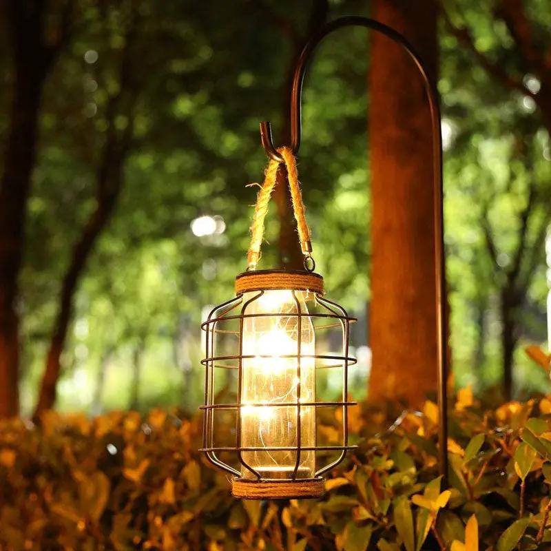 JHY DESIGN 9.4-inch battery-powered table lamp; lantern-style metal cage with glass jar and rope handle, warm glow