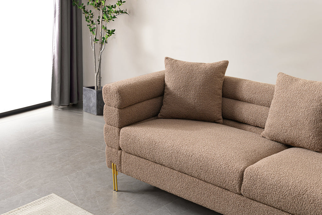 Luxurious and comfortable upholstered sofa with golden legs and pillows for living room and reception area