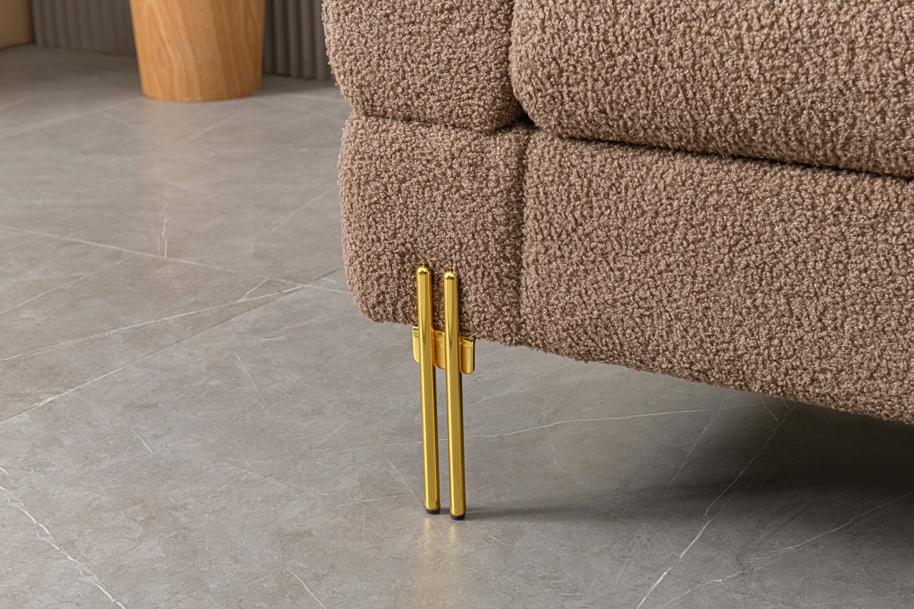 Luxurious and comfortable upholstered sofa with golden legs and pillows for living room and reception area