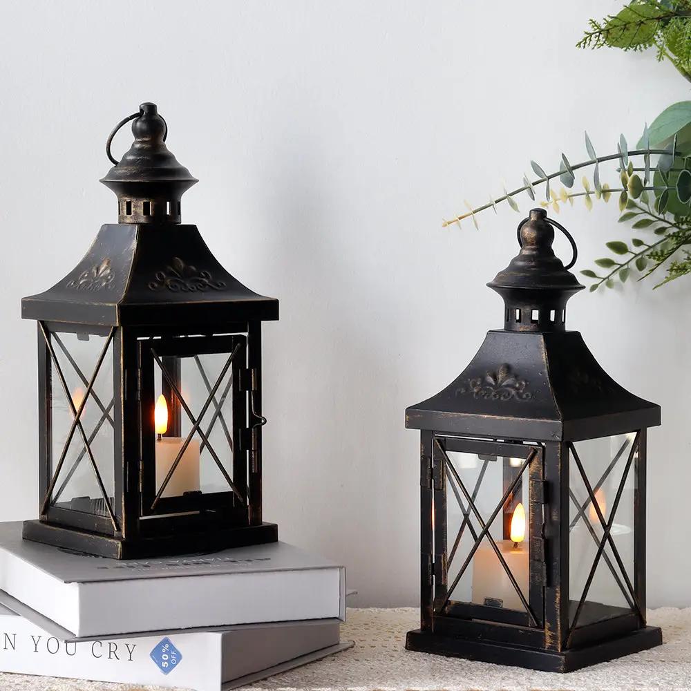 Set of 2 11-inch metal decorative candle lanterns with glass panes and distressed black finish.