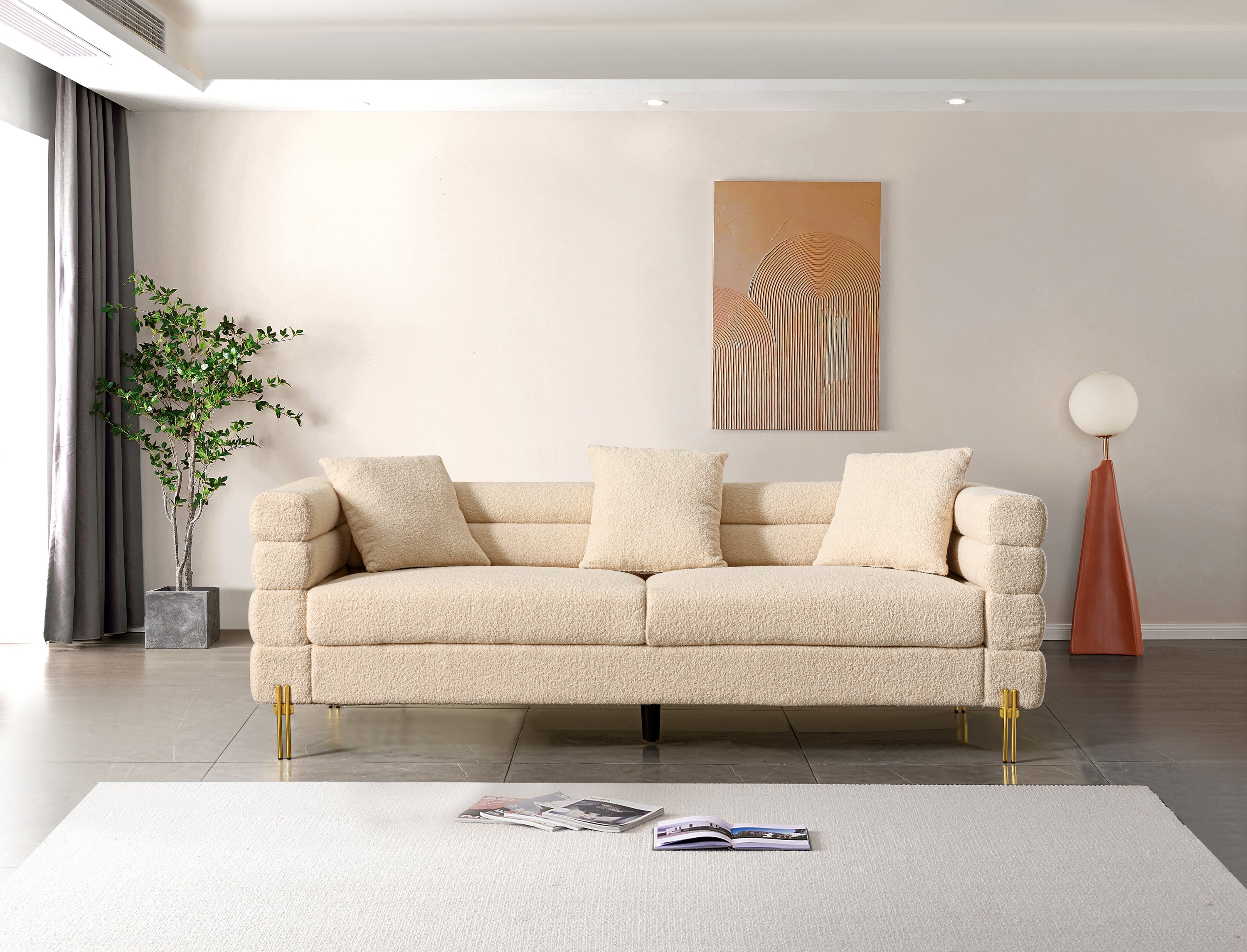 Luxurious and comfortable upholstered sofa with golden legs and pillows for living room and reception area