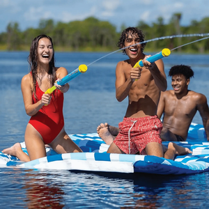 WOW Watersports Splash Cannon water toy; blue and yellow cannons used by three kids on an inflatable raft.