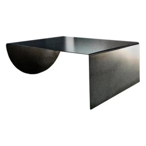 Asymmetrical heavy-duty raw-steel coffee table with curved arc support and flat top