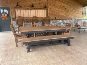 Harmony Outdoor Table by Wooden Whale Workshop with several brown wooden chairs on a covered patio.
